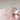 Clear glass of water on a pink pebble surface