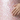 Hand touching a pink textured surface with fish scale pattern