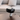 Black and white electronic device on a table with a sofa in the background