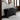 Modern black console table with a book and decorative object in a room with a mirror and window.