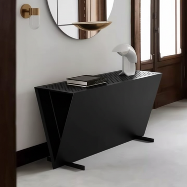 Modern black console table with a book and decorative object in a room with a mirror and window.