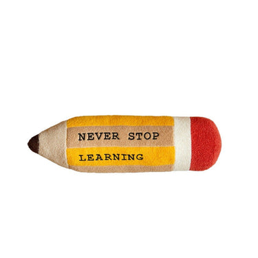 A pencil-shaped plush toy or pillow with the words 'NEVER STOP LEARNING' printed on it, set against a plain white background.