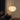 Floor lamp with a white woven shade in a dimly lit room.