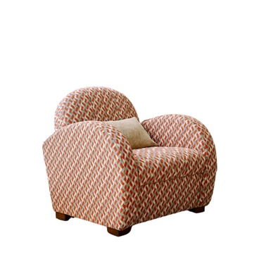 Comfortable armchair with rounded arms and back, featuring a red and white geometric pattern and a beige accent pillow