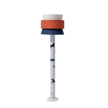 Modern floor lamp with stacked cylindrical fabric shades in white, orange, and navy blue over a patterned tall slender pole