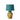 A table lamp with a green linen lampshade and a ceramic base featuring a colorful floral and animal pattern.