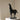 Black horse sculpture on a white pedestal against a beige wall