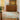 Kitchen with wooden cabinets, a rug on the floor, and a plant.