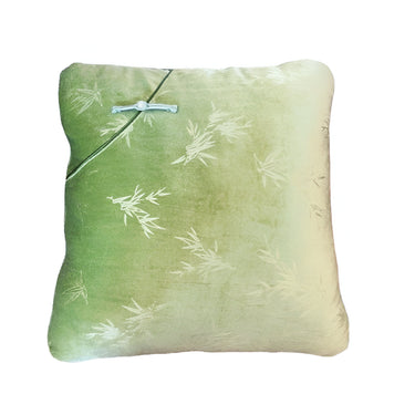 Green silk decorative pillow with subtle bamboo leaf pattern and traditional knot closure