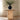 Small round table with a black vase and branches on a neutral background