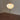 Floor lamp with a round white shade and black metal legs on a wooden floor.