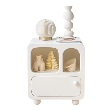 Modern white side table with round edges, decorated with sculptural vases, decorative tree, and pleated lamp