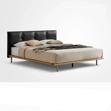 A brown leather bed frame with a wooden base and stainless steel legs, with a beige mattress on it.