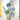 Decorative wall art with blue floral designs and greenery on a white wall.