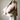Person holding two pink pillows with ties against a neutral background