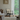 Living room with a chair, table, and large window showing greenery