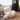 White fluffy chair and ottoman in a room with a window and side table.