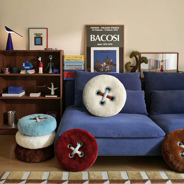 Living room with blue sofa, button-shaped cushions, and a bookshelf.