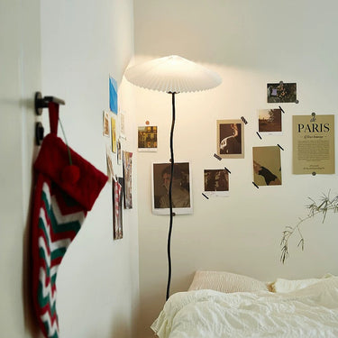 Bedroom with a lamp, bed, and wall decorations including a 'PARIS' poster.