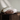 Two decorative pillows on a wooden surface with a neutral background
